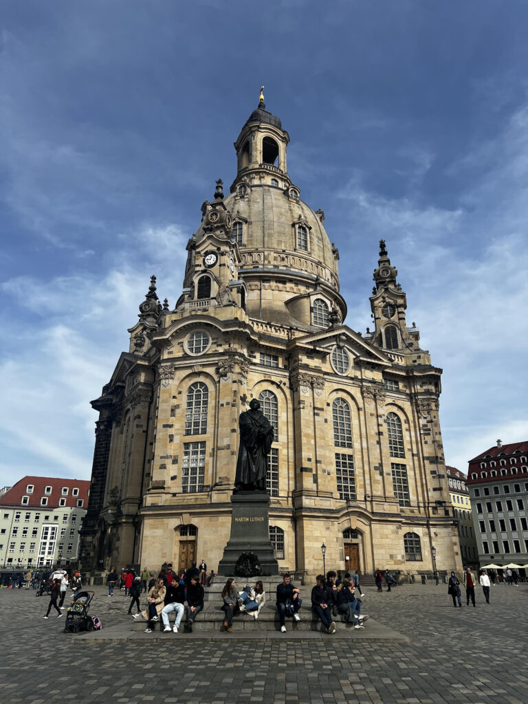 The outside of the Dresden Cathedral in the background of the Martin Luther Statue.