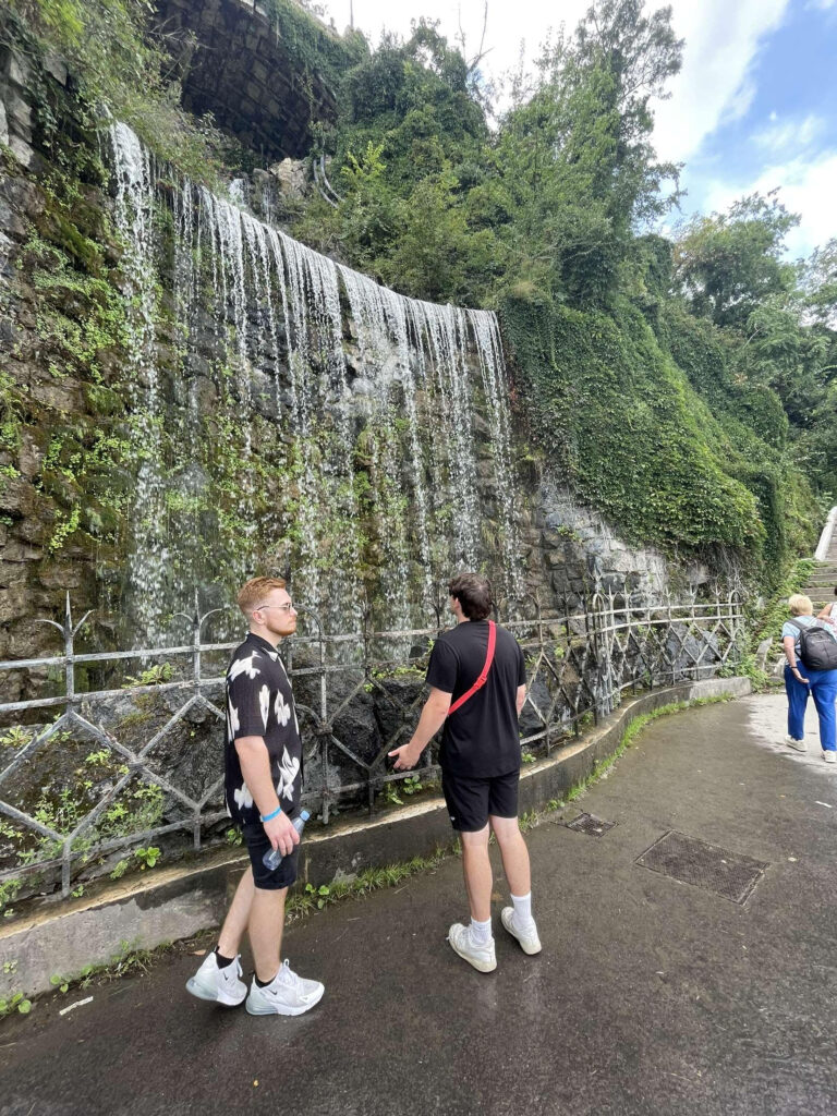 Author's friends, Josh and Sam, stood in front of a waterfall.