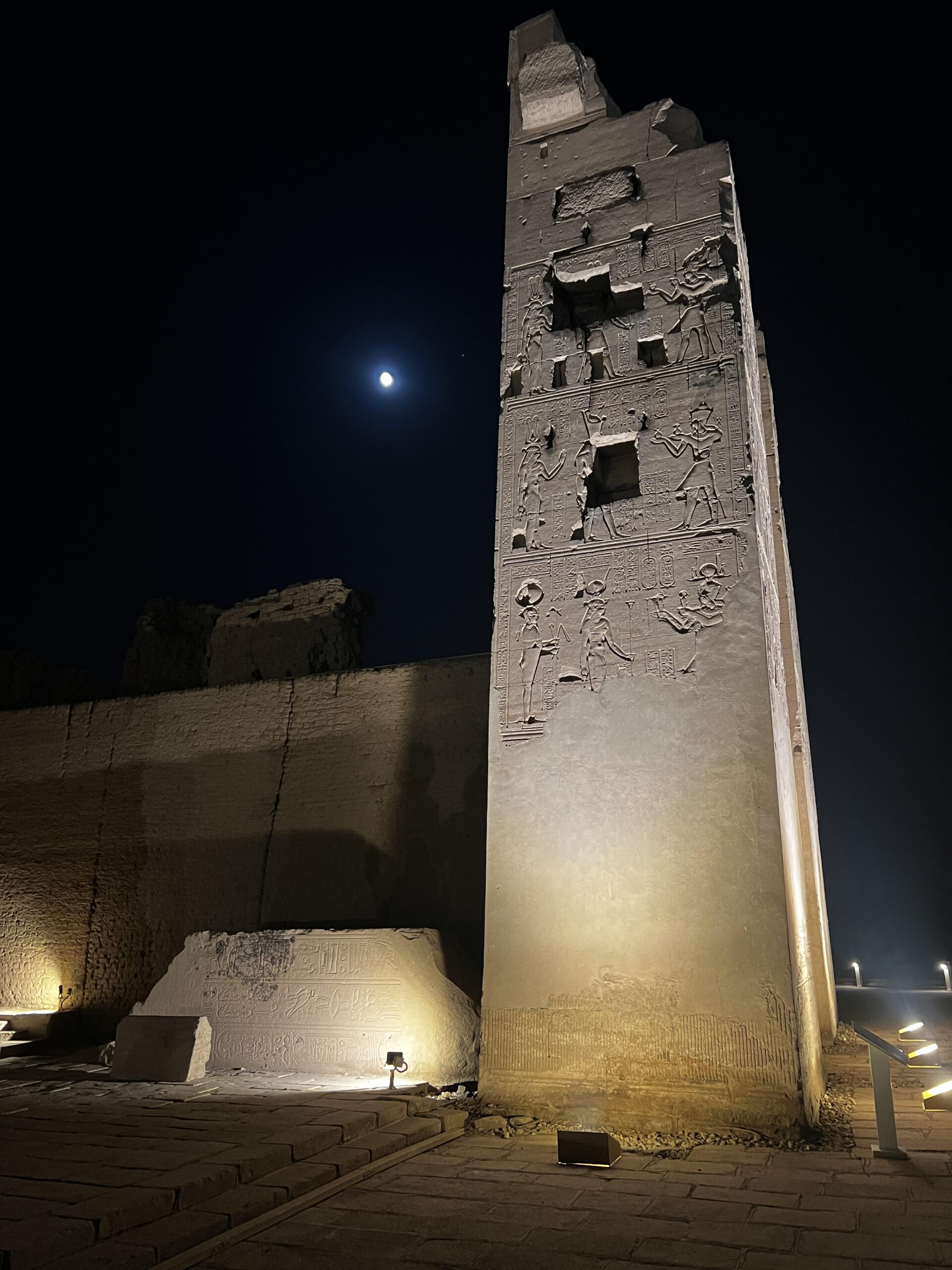 An image of on eof the pillars at the Kom Ombo temple in Egypt. The moon can be seen in the nightsky above.