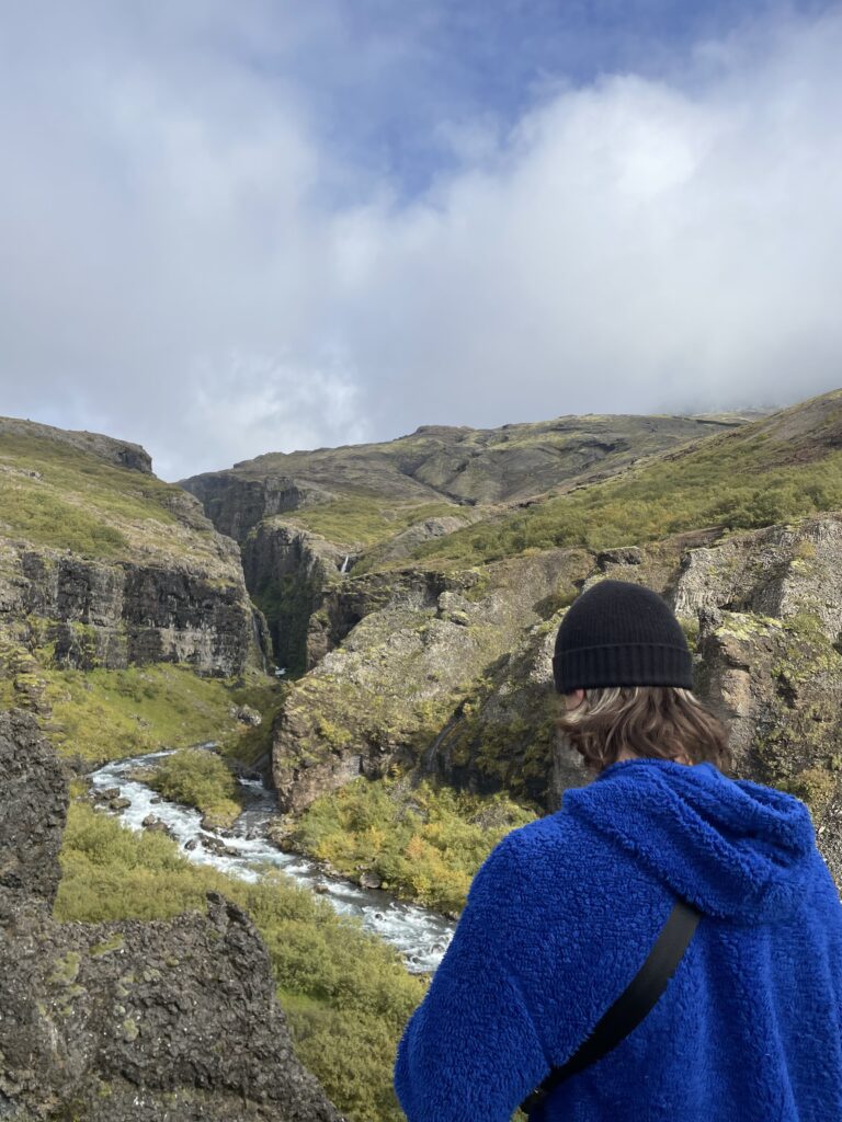 A shot of an Icelandic river valley with the author Tom in the shot