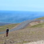 Two people, the author and his brother, looking out at the view from a hill in Iceland.