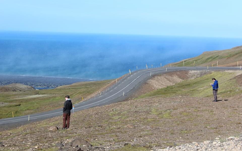 Two people, the author and his brother, looking out at the view from a hill in Iceland.