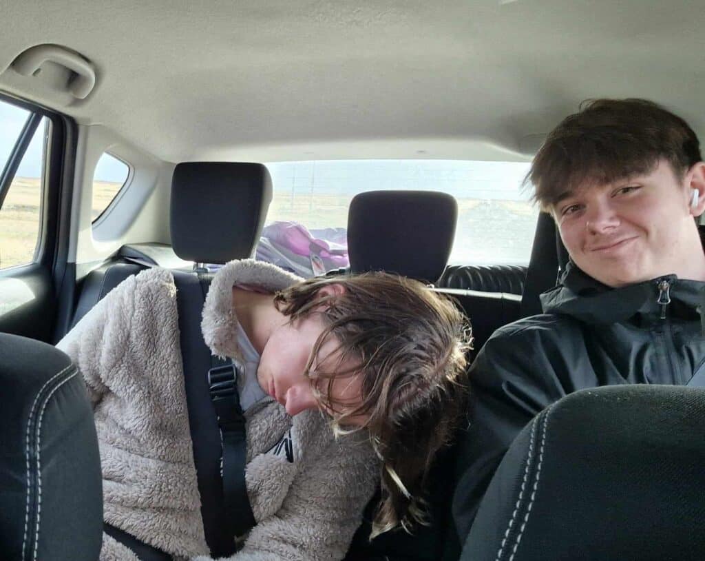 The author asleep in the back of a car next to his brother on a road trip.