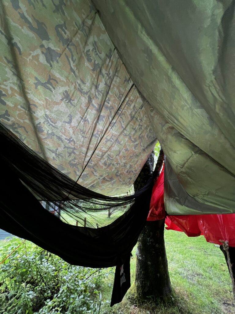 A hammock with a water shelter during a camping trip.