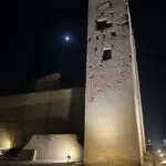 An image of on eof the pillars at the Kom Ombo temple in Egypt. The moon can be seen in the nightsky above.