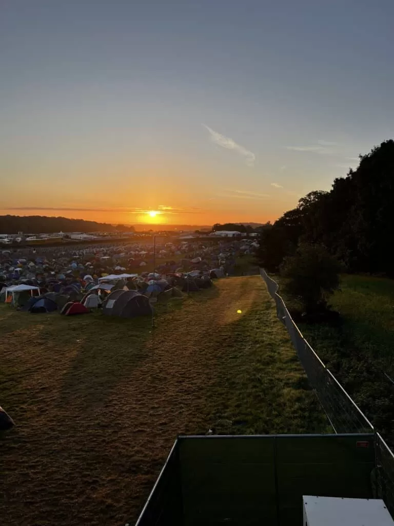 A view of a campsite from a fire tower just as the sun is rising.