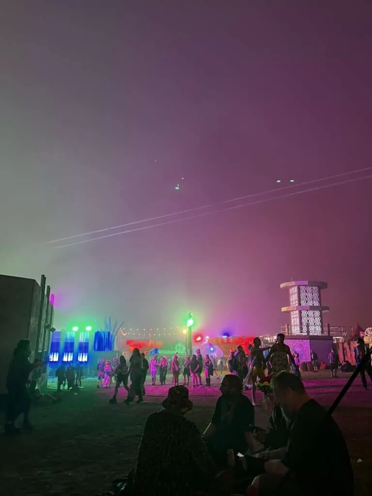 People walking in different directions within a certain part of Boomtown's main arena.